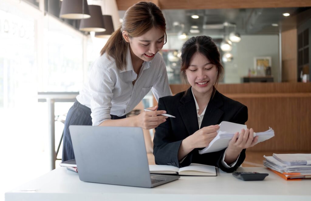 Two young asia business woman working together in office space